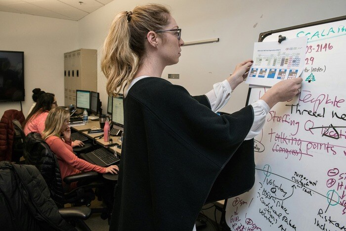 woman writing down information on whiteboard