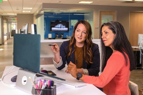 women working together on desktop